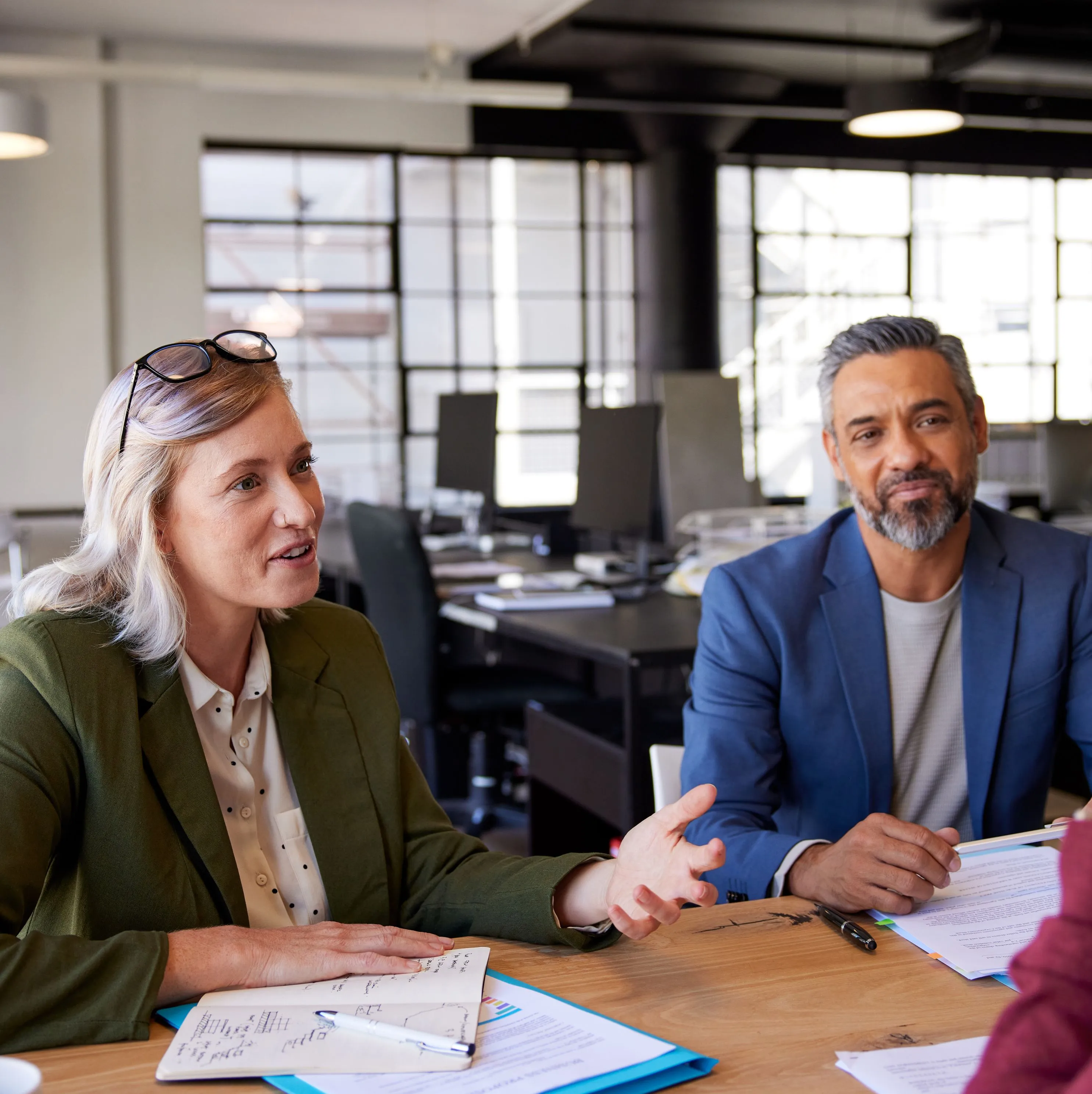 Two experienced professionals in discussion at an office table